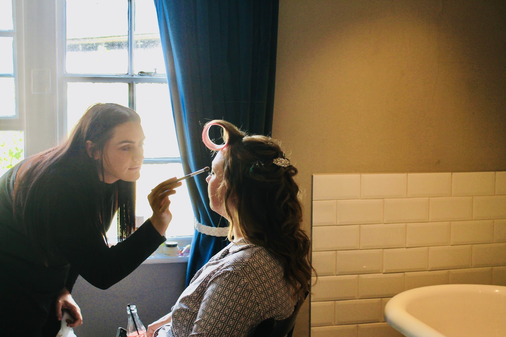 A stylist finishing a client’s hair by the window at Dye Vert